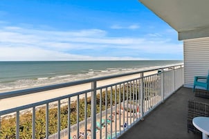 Een balkon met uitzicht op het strand en de oceaan.