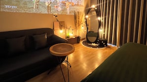 Een woonkamer met een bank, een klein rond tafeltje en een projectiescherm waarop een band te zien is.