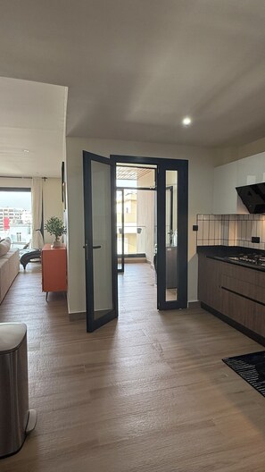 A modern apartment with a kitchen, living area, and balcony.