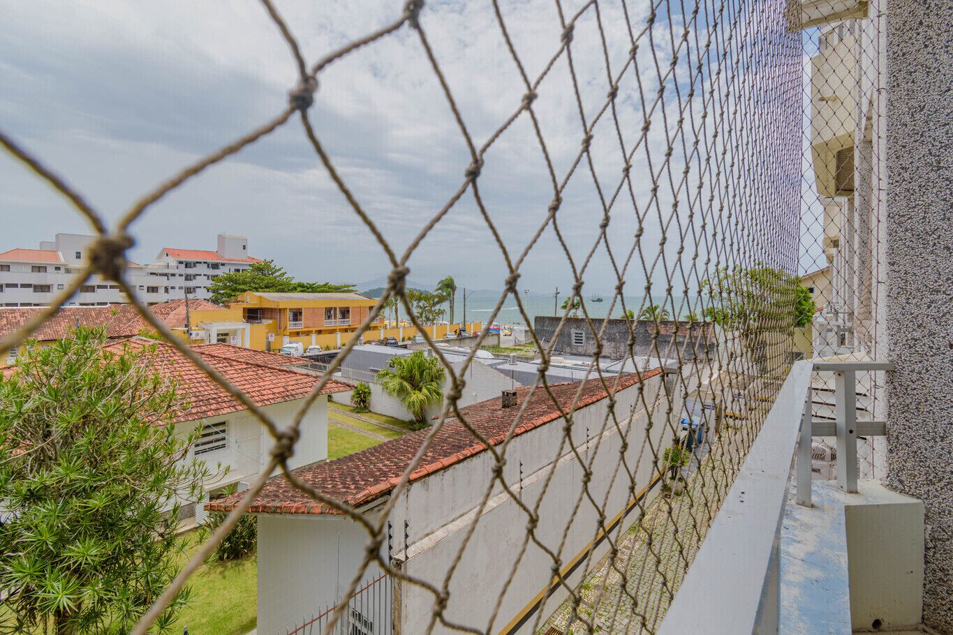 A residential area with houses, a clear sky, and a body of water in the background.