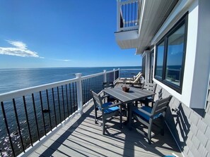 A deck with a table and chairs, overlooking the ocean. - 2-bedroom ocean-front Fairhaven home overlooking Buzzards Bay (Fairhaven)