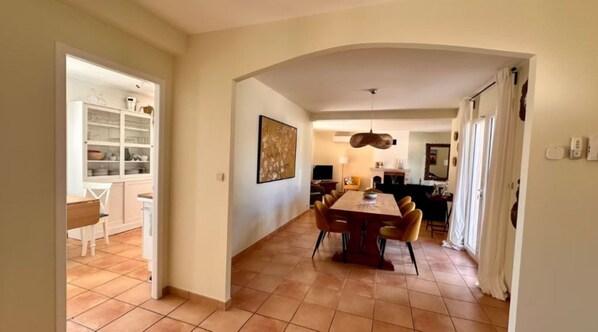 A spacious dining area with a large table and chairs, a kitchen with cabinets, and a living area with a fireplace.