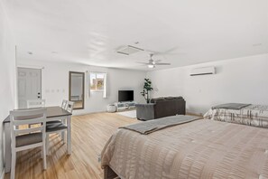 A bedroom with a bed, a desk, a chair, a television, and a ceiling fan. - Game On! River Getaway Sleeps 10 in Bullhead City (Bullhead City)