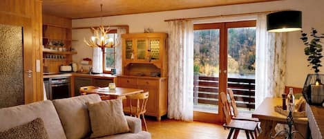 A cozy living room with a sofa, dining table, and kitchen area.