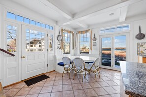 Una cocina con comedor, ventanas amplias y vistas al exterior.