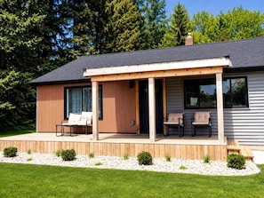 A modern house with a covered patio, a wooden deck, and a small garden area. - Port Sanilac Playland - SwimSpa - Family Friendly Swim All Yr! (Port Sanilac)