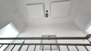 Un plafond haut avec une lucarne et une porte.