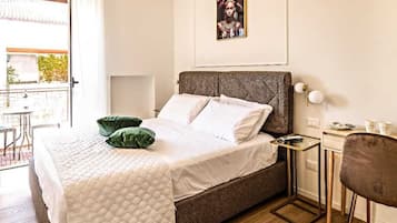Un dormitorio ordenado con cama, mesita de noche y una silla.