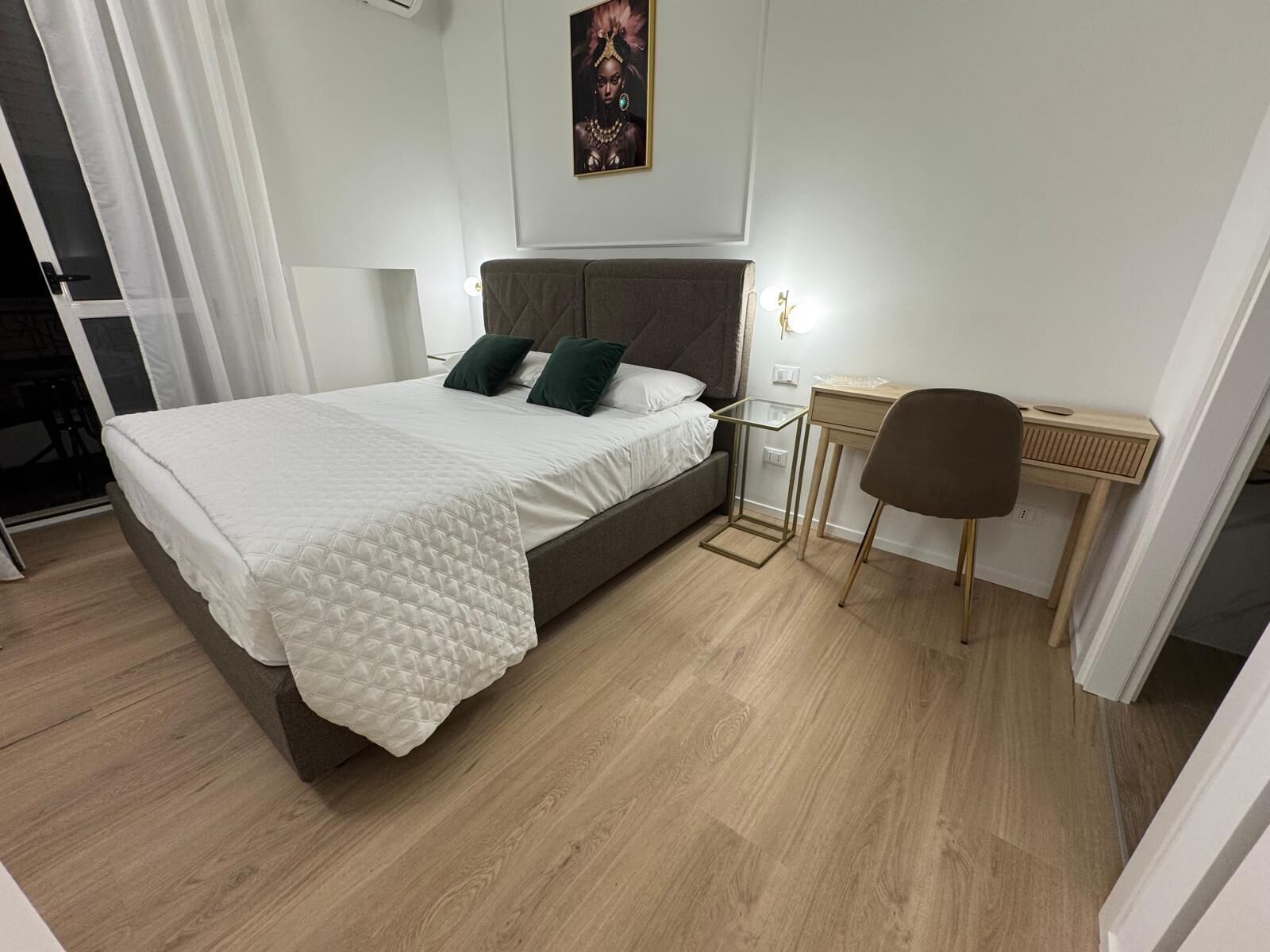 Une chambre à coucher moderne avec un lit, des tables de chevet, un bureau et une chaise.