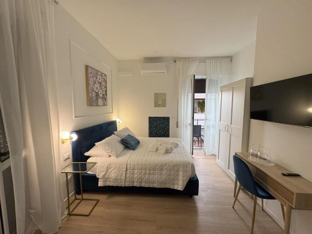 Un dormitorio con cama, mesita de noche y televisión.