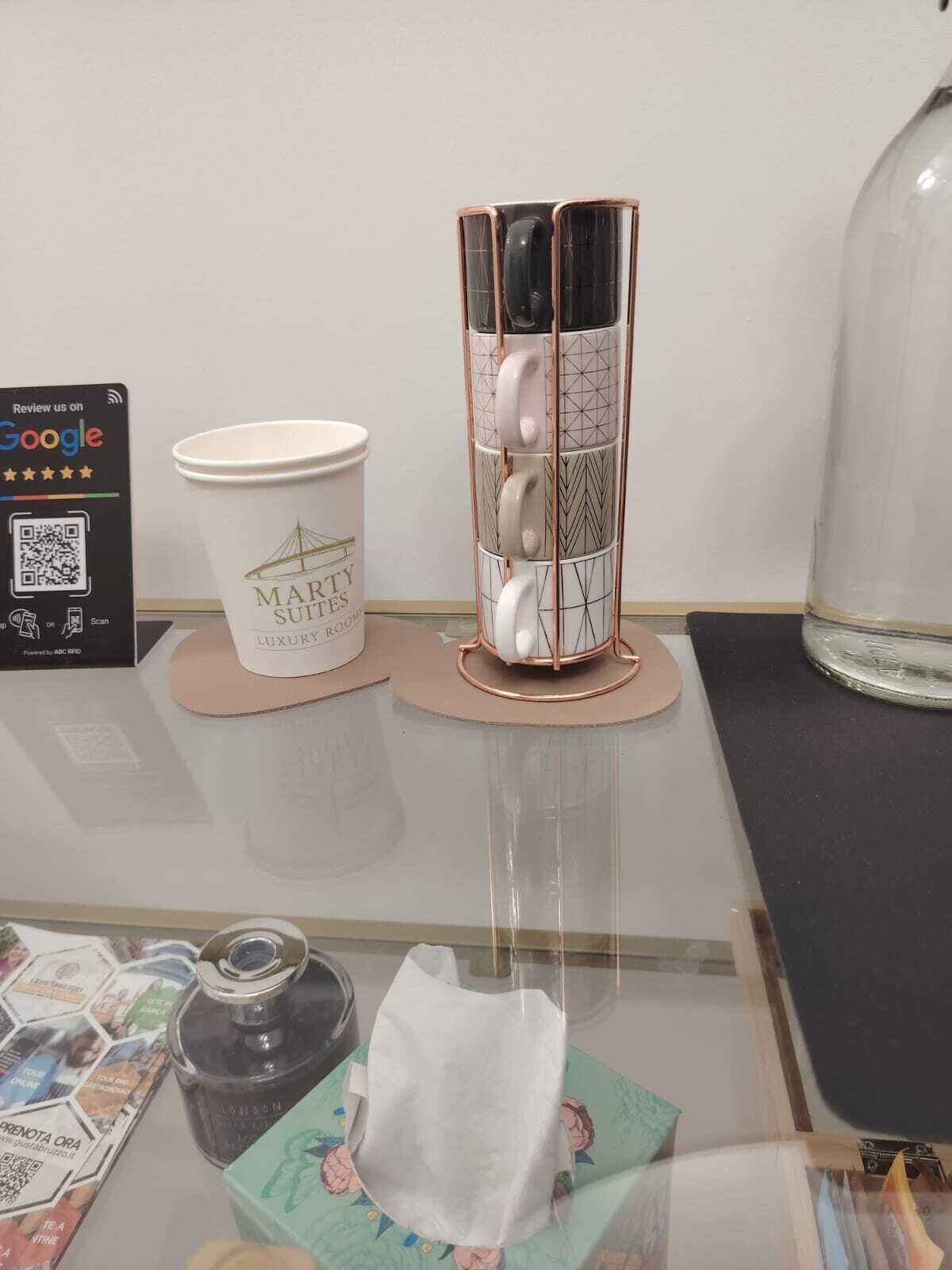 A coffee cup, a mug holder, a tissue box, and a glass jar on a table.