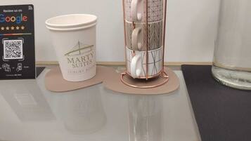 A coffee cup, a mug holder, a tissue box, and a glass jar on a table.