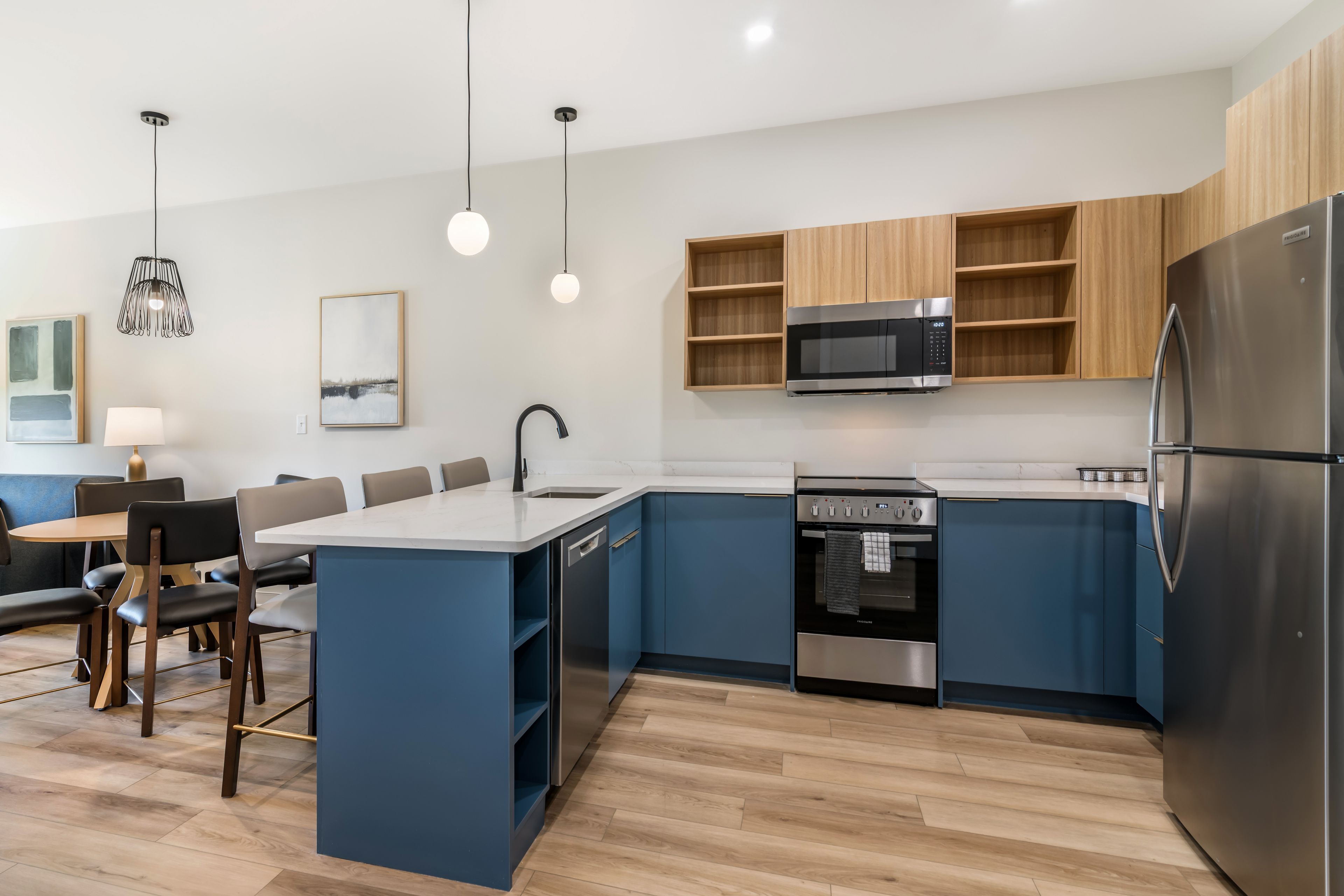A modern kitchen with a central island, built-in microwave, oven, and refrigerator.