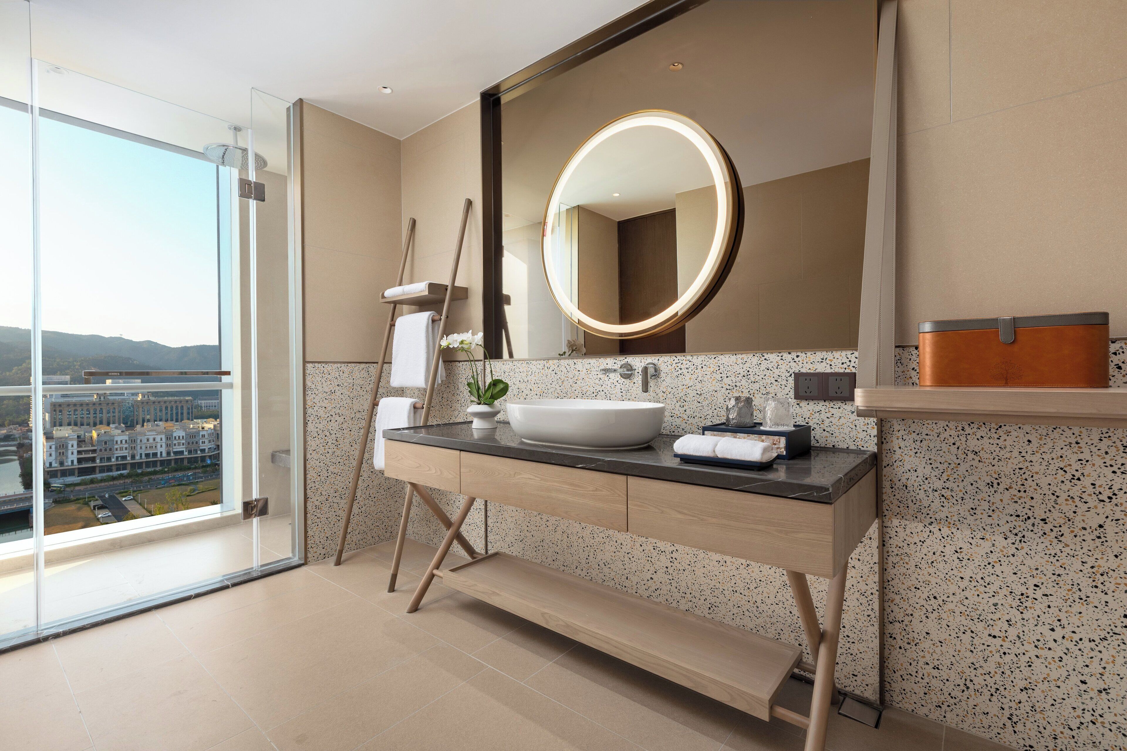 A modern bathroom with a large mirror, a sink, and a vanity.
