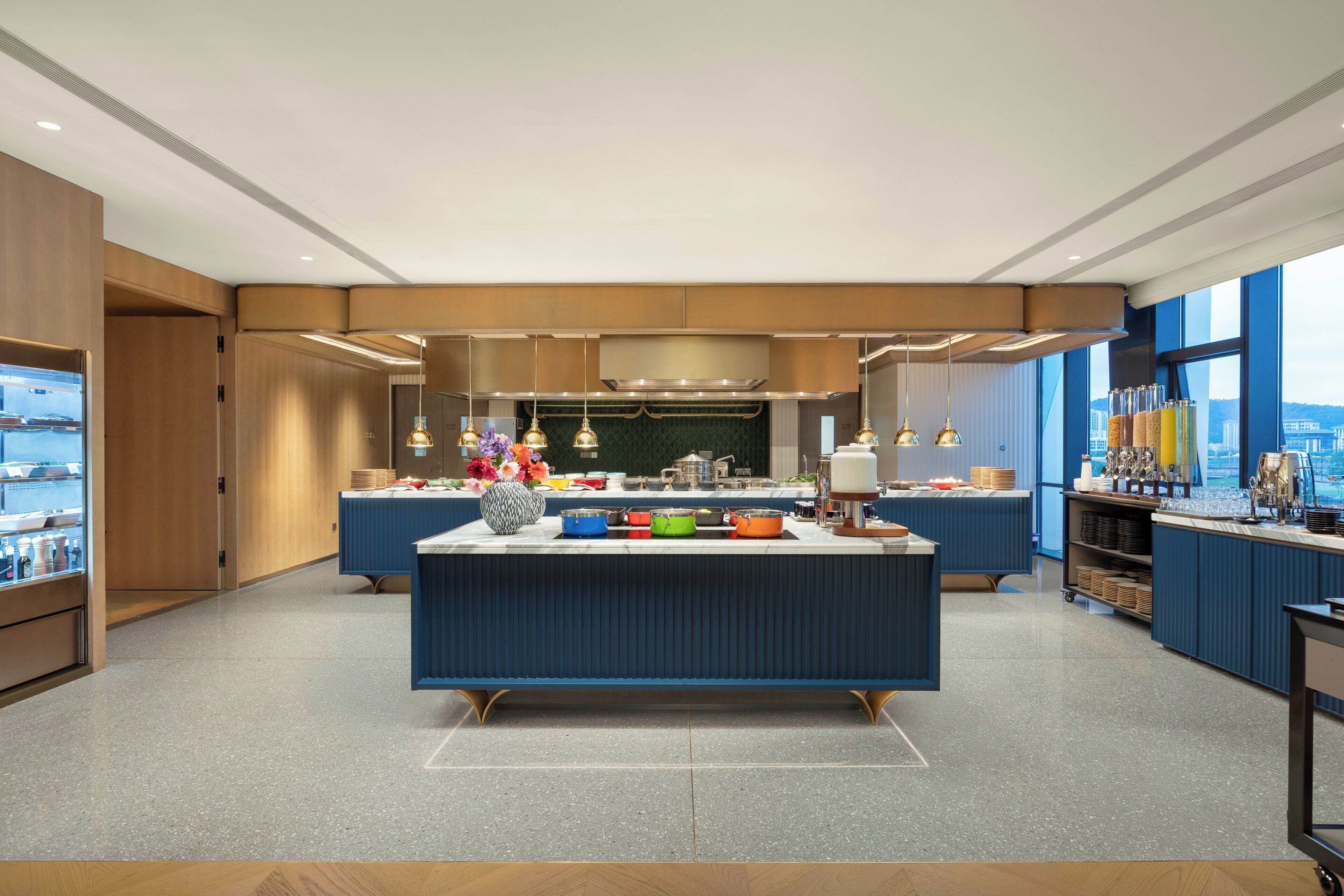 A modern kitchen with a central island, built-in appliances, and a view of the city.