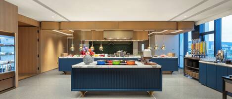 A modern kitchen with a central island, built-in appliances, and a view of the city.