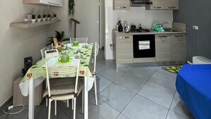 A compact living space with a dining area, kitchenette, and a bed. - The Torrione Anchor (Salerno)