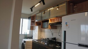 Eine moderne Küche mit eingebauter Mikrowelle, Edelstahlgeräten und einem Kühlschrank.