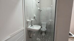 A bathroom with a shower, sink, and toilet.