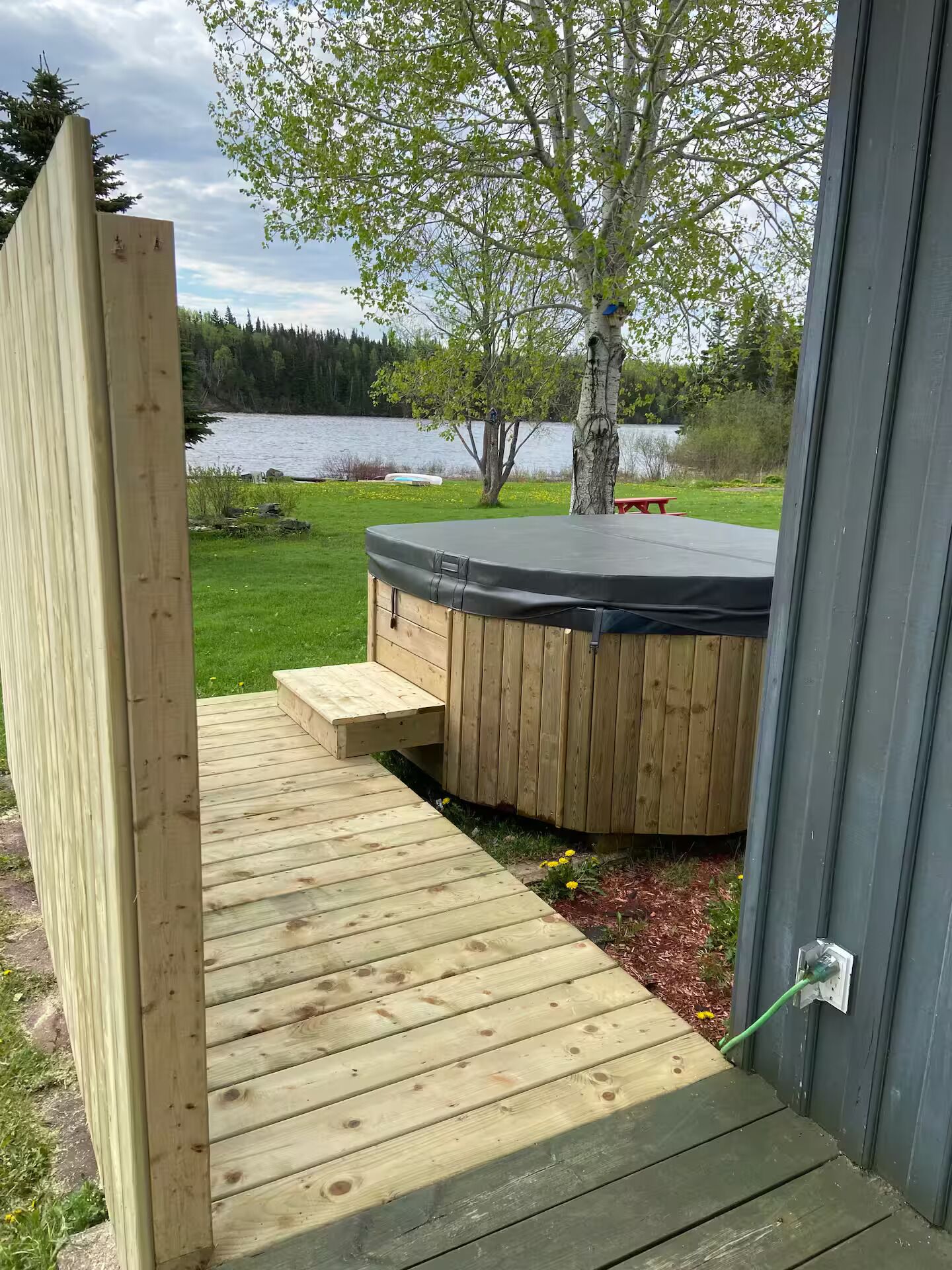 Puinen terassi, joka johtaa porealtaaseen, josta avautuu näkymä järvelle ja puustoon.
