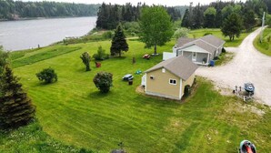 A house with a large yard, a lake, and a dirt road. - Great for couples - The Riverview Suite (Reidville)