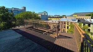 A rooftop with a metal grid floor, surrounded by buildings and trees. - Prospect Heights/Clinton Hill. 2 balconies, elevator, top floor, washer / dryer (New York)