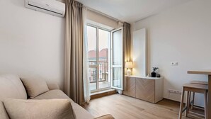Een moderne, goed verlichte kamer met een bank, een tafeltje en een kast.