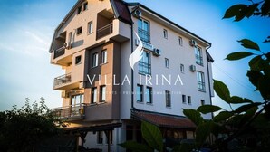 Ein mehrgeschossiges Gebäude mit Balkonen und einem Schild mit der Aufschrift "Villa Irina".