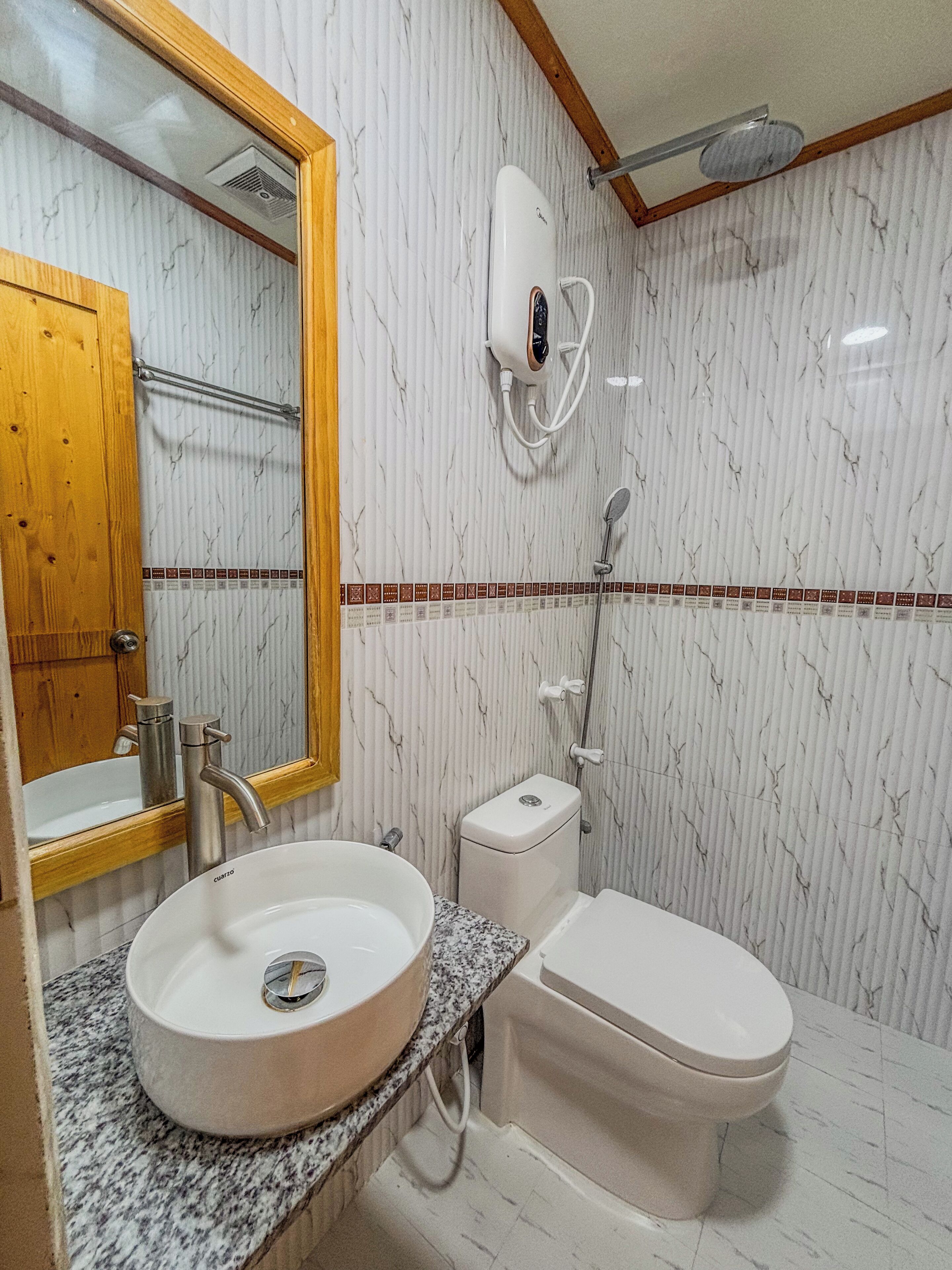 A bathroom with a sink, toilet, and shower.