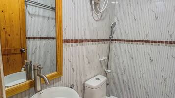 A bathroom with a sink, toilet, and shower.