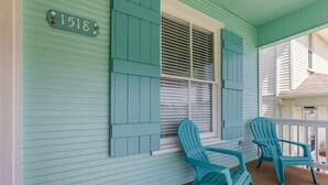 A porch with teal shutters and two Adirondack chairs. - Surf House Galveston (Galveston)