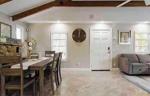 A dining area with a wooden table and chairs, a clock on the wall, and a fan. - 2-ensuite bedrooms detached beach house& yard in superb Delray 1 milefrom beach (Delray Beach)