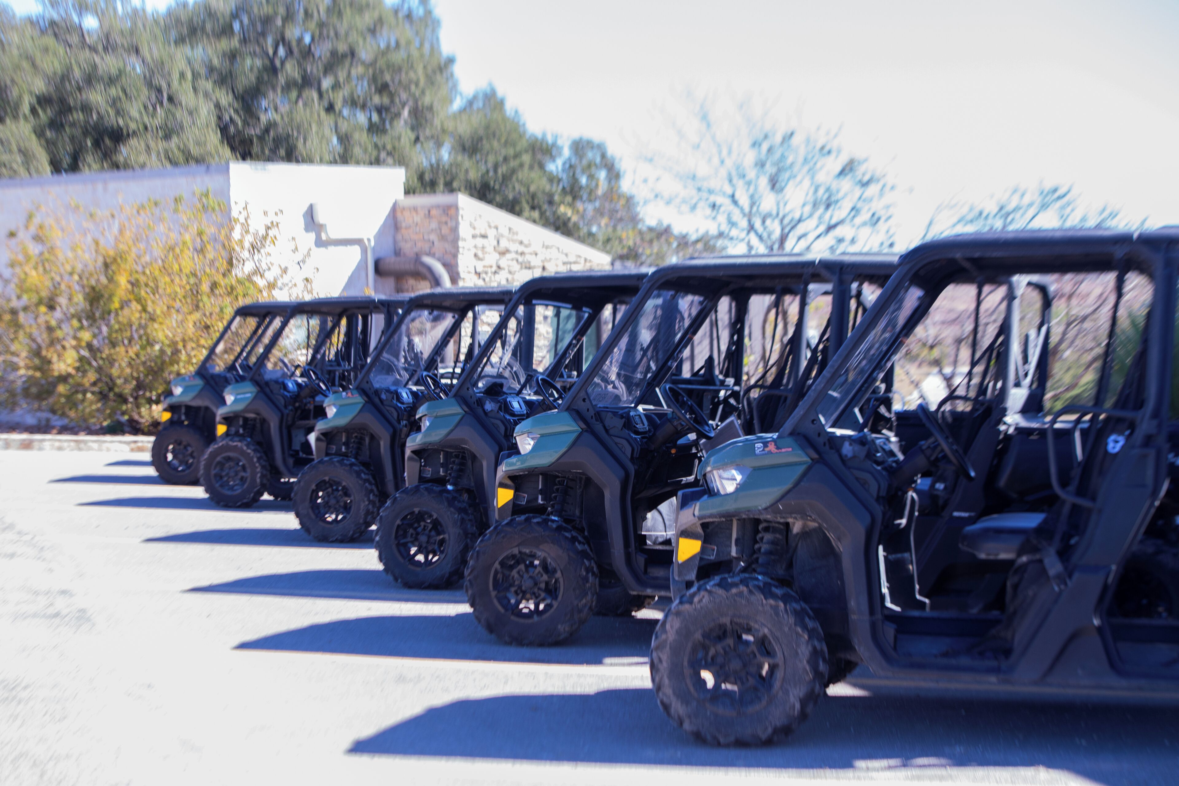 A row of four off-road vehicles parked in a line.