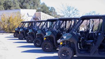 A row of four off-road vehicles parked in a line.