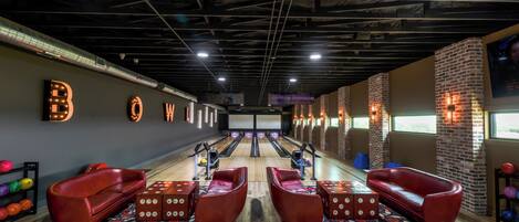 En bowlinghal med røde læderstole, trægulv og en murstensvæg.