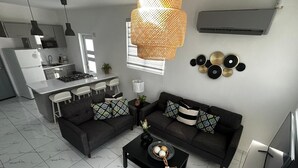 Een moderne keuken met een centraal eiland, twee donkere banken met geknoopde kussens, een salontafel met decoratieve objecten, en een hangende rotanlamp.