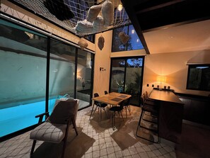 An outdoor dining area with a pool, a table, chairs, and a bar. - Super Loft House Style with Private Pool and Garden (Tulum)