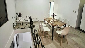 A dining area with a table and chairs, a ceiling fan, and a white wall. - Beach House in Huacas | Near Tamarindo (Huacas)