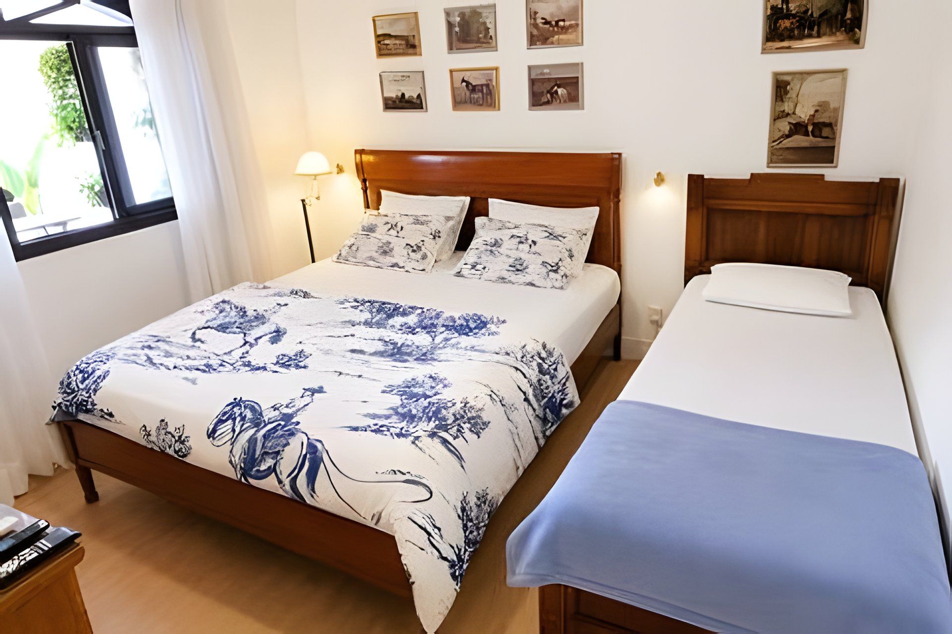 A bedroom with a bed, a bedside table, and a window.