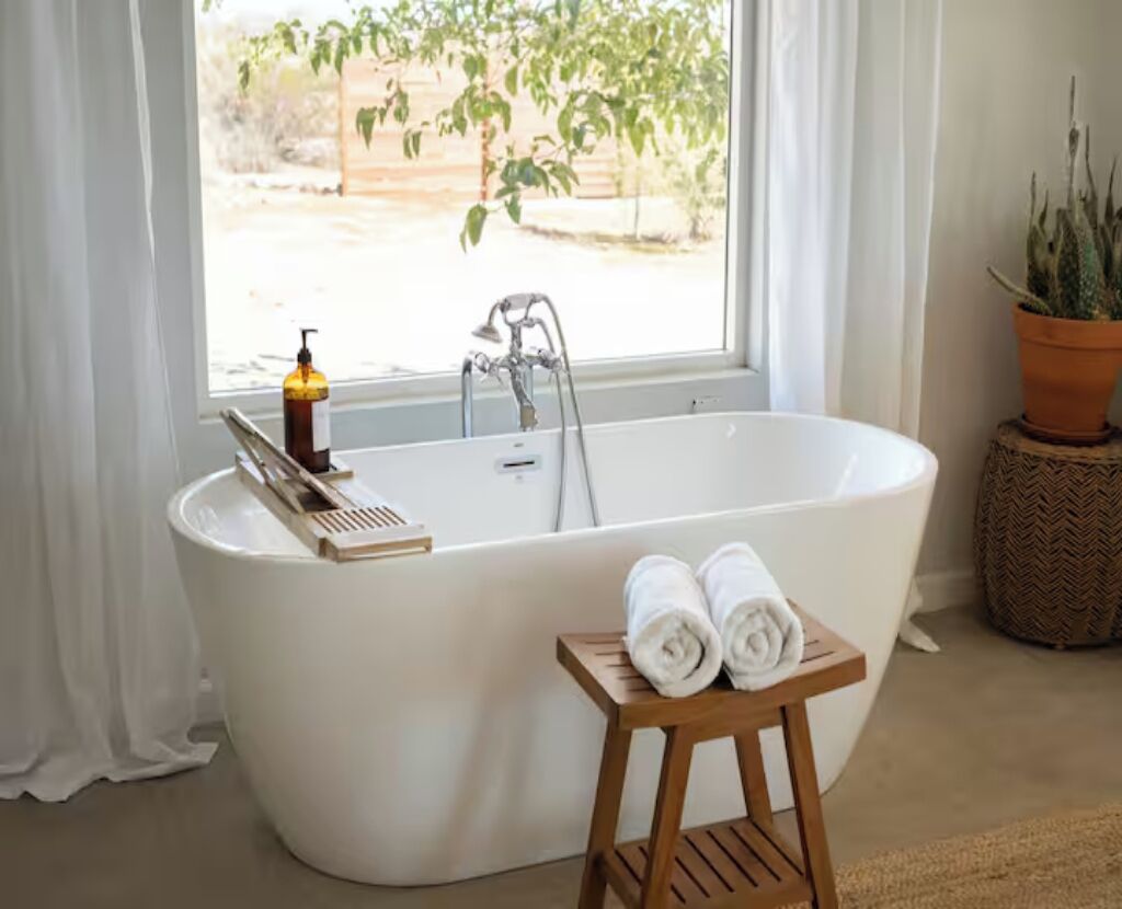Spa-like soaking tub with sunny window views and calming natural touches