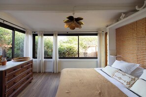 A bedroom with a large bed, a wooden dresser, a ceiling fan, and a window with curtains. - MerSea Beach House at only 10 meters from the Beach in Sainte-Maxime. (Sainte-Maxime)