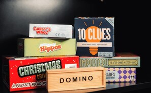 A collection of board games including 'Guess Who!', '10 Clues', 'Hippos', 'Christmas Trivia', 'Imposter!', and 'Domino'.