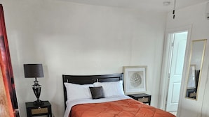 A bedroom with a bed, nightstands, a lamp, a mirror, and a door. - 216 Panoramic Single Room in a waterfront hotel in Singer Island, FL (Riviera Beach)