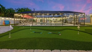 A modern house with a glass-enclosed patio, a swimming pool, and a well-maintained lawn. - Epic Backyard - Pool - Hot Tub - Outdoor Theatre (Bradenton)
