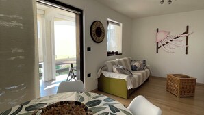 A modern bedroom with a bed, a window, a wall clock, and a view of the outdoors. - Residence4a- Apartman Bianco - u blizini mora, idealan za opuštanje (Ravni)