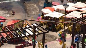 Une plage où l’on peut se baigner et bronzer, avec des parasols et un petit kiosque.