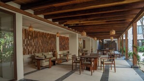 A spacious indoor area with wooden furniture, a stone-tiled floor, and a wooden ceiling. - Luxury Apartment in Tulum - Private Pool - Sleeps 8 (Tulum)