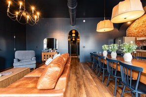 A modern interior with a leather sofa, dining area, and kitchen. - Hollyhock Suite 401: 4 bed/2 bath with soaking tub (Louisville)