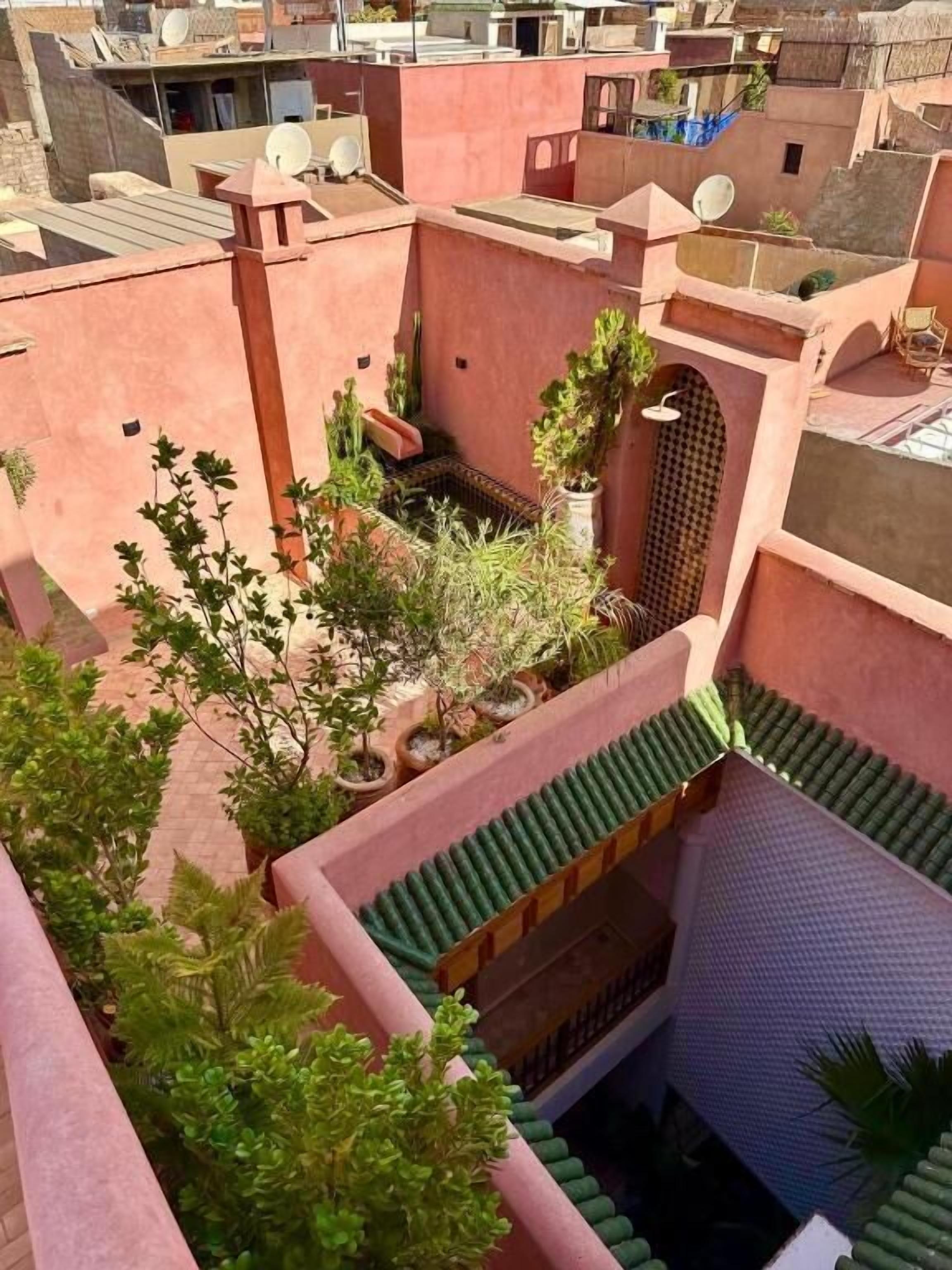 A courtyard with potted plants and a tiled roof.