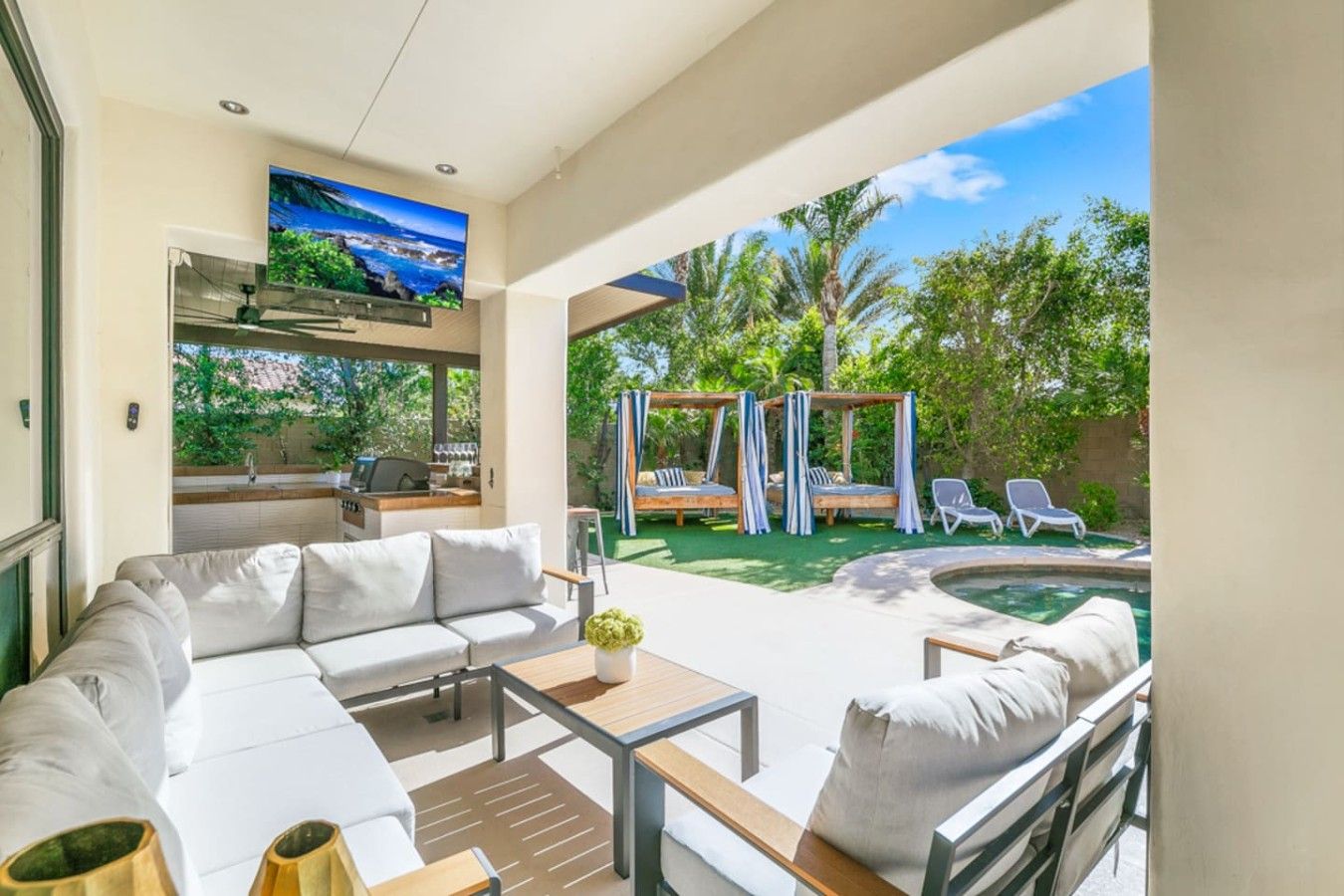 Un espace de vie extérieur moderne comprenant un canapé, une table basse et une piscine.